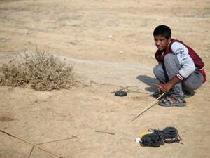 الفلسطيني حمزة أبو شلهوب يحاول اصطياد طيور مغردة في أطلال مطار غزة الدولي

