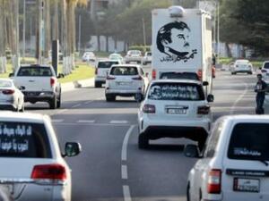 صور أمير قطر الشيخ تميم بن حمد آل ثاني على السيارات في أحد شوارع الدوحة

