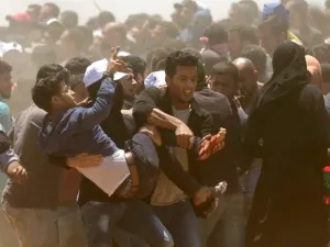 فلسطينيون يحملون جريحا اصيب برصاص القوات الاسرائيلية على حدود غزة