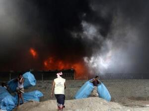 عمال إغاثة يحاولون انقاذ مساعدات غذائية من الحريق الذي اندلع في مخازن تابعة لبرنامج الأغذية العالمي في مدينة الحديدة الساحلية على البحر الأحمر
