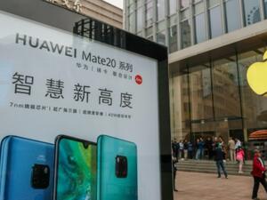 لوحة إعلانية لشركة هواوي أمام متجر آبل في شانغهاي
