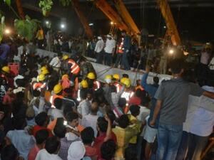 عاملو إغاثة ومارة يتجمعون حول موقع انهيار جسر في مدينة فاراناسي في ولاية اوتار براديش في شمال الهند
