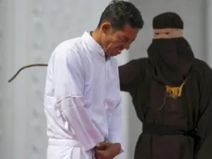 جون سيمبولون اثناء تنفيذ حكم الضرب بالعصي فيه

