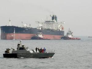 زورق دورية إيران في مياه الخليج على مقربة من ناقلة نفط تستعد للرسو في ميناء جزيرة خرج النفطي

