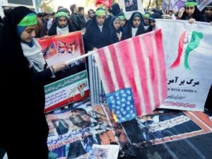 فتاة ايرانية تحرق علما اميركيا امام مقر السفارة الاميركية سابقا في طهران
