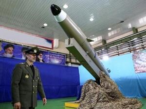 وزير الدفاع أمير حاتمي يقف أمام الجيل الجديد من صاروخ "فاتح مبين" البالستي خلال مراسم الكشف عنه في طهران
