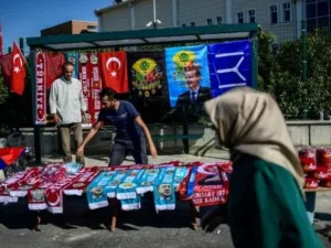 امرأة تسير أمام بسطة لبيع شالات تحمل صور الرئيس رجب طيب اردوغان قرب محكمة سجن سليفري في اسطنبول
