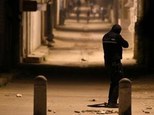 احد افراد قوات الامن التونسية يواجه محتجين في حي التضامن ضاحية العاصمة
