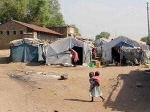 طفلة تحمل أخاها في مخيم للنازحين داخليا في جوبا
