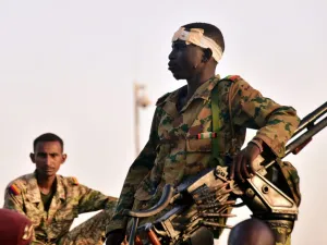 جنود من الجيش السوداني يتابعون احتجاجا يطالب بتنحي الرئيس عمر البشير أمام وزارة الدفاع في الخرطوم

