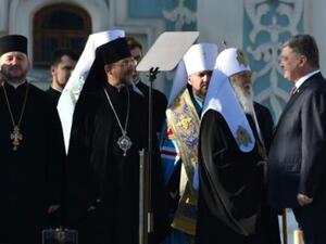 الرئيس الاوكراني يصافح البطريرك فيلاريت اثناء القداس في كييف الاحد
