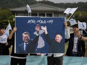 ناشطون يحملون صورة تجمع الزعيمين الكوريين كتب عليها "السلام بداية جديدة" خلال تظاهرة امام القصرالرئاسي في سيول
