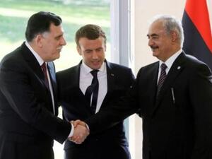 الرئيس الفرنسي ايمانويل ماكرون يتوسط مصافحة بين رئيس حكومة الوفاق الوطني الليبية فايز السراج وخصمه المشير خليفة حفتر، الرجل القوي في شرق ليبيا
