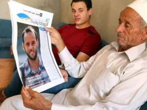 عبد الله حميدة يحمل صورة ابنه عبد القادر الذي سقط اثناء قتاله ضمن قوات حكومة الوفاق الوطني الليبية لاستعادة سرت
