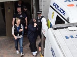 عناصر من الشرطة يقتادون امراة إلى سيارة شرطة خلال مداهمة في باركينج بشرق لندن يوم الاحد
