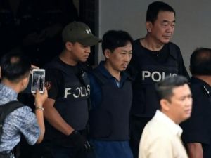 الكوري الشمالي ري جونغ شول (وسط) بين عناصر الشرطة بعد اخلاء سبيله في مركز الشرطة في سيبانغ

