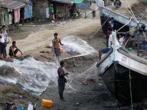 رجال يصلحون الشباك في مخيم للاجئي الروهينجا خارج بلدة سيتوي بولاية راخين بميانمار
