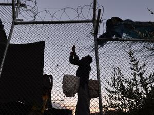 Migrants fix their makeshift tent made from blankets in the Moria camp, on the island of Lesvos, on September 20, 2016. (AFP/Louisa Gouliamaki)