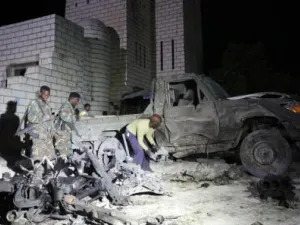 جنود ورجال شرطة صوماليون يعاينون موقع هجوم إنتحاري بسيارة ملغومة قرب البرلمان في العاصمة مقديشو يوم السبت
