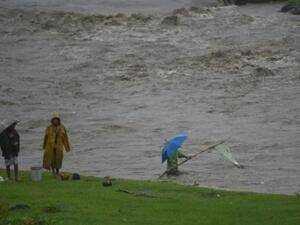 فيليبينون ينتشلون أغراضا من نهر قرب البركان مايون
