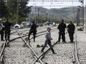 A boy walks acros rail tracks during a police operation to clear a makeshift camp for refugees and migrants at the border between Greece and Macedonia near the village of Idomeni, northern Greece on May 25, 2016. (AFP/Yannis Kolesidis)