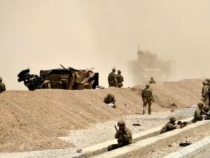 جنود اميركيون يراقبون على مقربة من آليتهم التي دمرت في هجوم انتحاري لطالبان في قندهار
