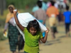 طفلة من اللاجئين الروهينغا تحمل مساعدات قي مخيم في منطقة اوخيا ببنغلادش
