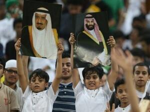 مشجعون سعوديون يحملون صور العاهل السعودي الملك سلمان وولي العهد الامير محمد في الخامس من ايلول/سبتمبر في جدة خلال مباريات في كرة القدم بين فريقي السعودية واليابان.

