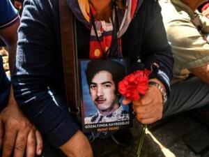 والدة تحمل صورة ابنها المفقود خلال تجمع في شارع الاستقلال في اسطنبول
