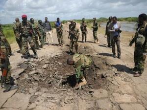 جنود صوماليون يتفقدون موقع انفجار سيارة قتل فيه عنصر من القوات الخاصة الاميركية في جنوب الصومال

