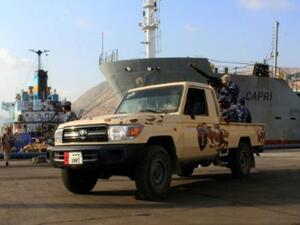 قوات يمنية موالية للحكومة تتولى حراسة سفينة في ميناء المكلا جنوب غرب اليمن
