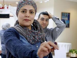An Egyptian woman living in Oman casts her vote on a divisive draft constitution in Egypt at the Egyptian embassy in the Gulf sultanate's capital Muscat on January 8, 2014. [AFP]
