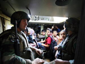 Lebanese army soldiers evacuate civilians caught in sniper fire in the Lebanese northern coastal city of Tripoli on November 30, 2013.  [AFP]