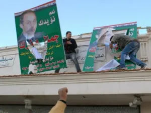متظاهرون ينزعون صور نجل الرئيس مبارك في الاسكندرية/أ.ف.ب