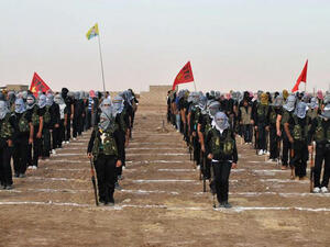 A picture taken on July 18, 2013 shows Kurdish opposition fighters attending a ceremony the northern Syrian border village of al Qamishli (AFP/STR)