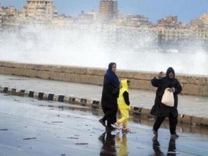 مصريون يمرون بجانب شاطئ في الاسكندرية بعد الامطار الغزيرة التي شهدتها المدينة