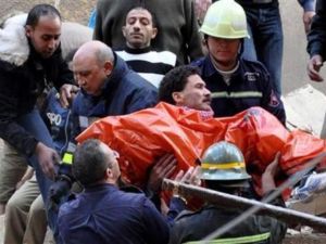عمال الانقاذ ينتشلون جثة من بين انقاض المصنع الذي انهار بمدينة الاسكندرية المصرية