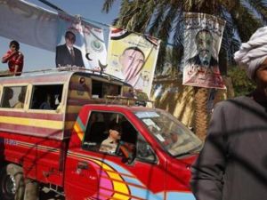 ناخبون يمرون أمام ملصقات لمرشحين في انتخابات مجلس الشعب بالاقصر في جنوب مصر