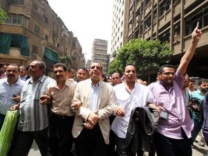 Egyptian Journalists Syndicate president Yahiya Kallash, secretary general Gamal Abd el-Rahim, and freedoms committee chief Khaled el-Balshy march and shout slogans after leaving the courthouse in Cairo on June 4, 2016. (AFP/Stringer)