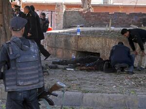 Egyptian security forces check a body at the site of a bomb attack next to a police checkpoint in the western Talibiya district of the capital Cairo on December 9, 2016. (AFP/Stringer)
