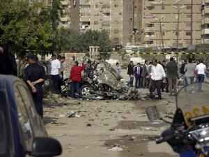 Egyptian policemen inspect the wreckage of a car after a bomb exploded in the eastern Nasr City district of the Egyptian capital Cairo on November 4, 2016. (AFP/Suhail Saleh)
