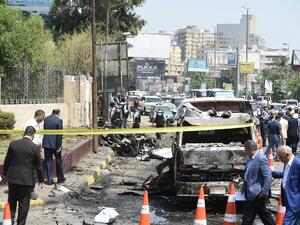 People gather as members of the Egyptian criminal lab inspect the remains of burnt vehicles in the capital Cairo on August 6, 2018. (Khaled DESOUKI / AFP)