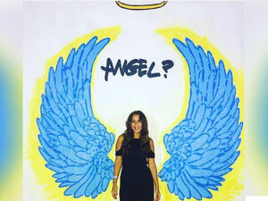 A fan stands in front of one of Radwan's murals. (Instagram / nadinkhalifa)