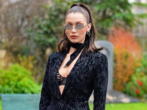 Hadid wore a mesh bodysuit and oversized 1980s power suit with a pair of white sneakers and long-length socks in what turned out to be a rather odd mix-and-match outfit. (Source: @bellahadid - Instagram)