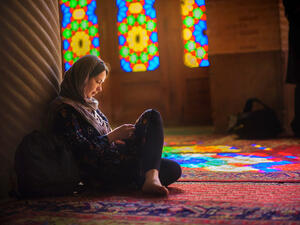 A girl reads inside an Iranian mosque. (fotosaga / Shutterstock.com)