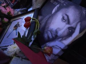 A message bearing a portrait of late British singer George Michael is seen amid flowers, candles and other messages left by well-wishers in tribute outside the singer's home in north London on December 27, 2016. (AFP/Niklas Halle'n)