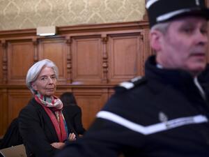 IMF chief Christine Lagarde next to a Gendarme prior to the start of her trial before the Court of Justice of the Republic, a special tribunal used to try ministers. (AFP/Martin Bureau)