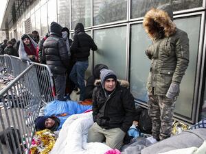 Refugees queue up in front of the refugee reception platform of France Terre d'asile NGO on boulevard de la Villette, northern Paris on January 26, 2017. (AFP/Geoffery van der Hasselt)