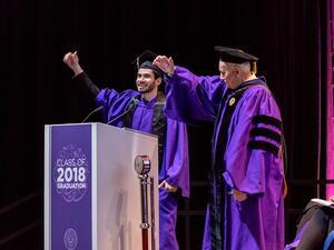 فؤاد حسن، المتحدث باسم طلاب الجامعة في حفل التخرج  وإيفيرت دينيس، عميد جامعة نورثويسترن في قطر  يؤدون هتاف الجامعة.