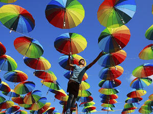 A Palestinian worker of a beachside coffeehouse decorates its terrace with hanging colourful umbrellas as part of decorations for the Muslim holy fasting month of Ramadan in Gaza. (AFP/File)